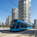 רכבת קלה עוברת ברחוב עירוני מודרני עם בניינים גבוהים