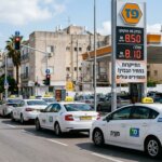 תחנת דלק ישראלית עם שלטי מחירים גבוהים לצד מוניות חדשות